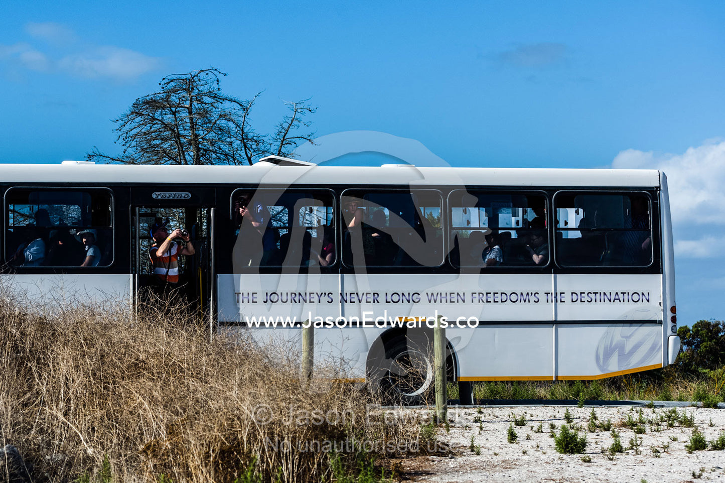 Tourists photograph a prison sulphur mine from a tour bus. Robben Island, Cape Town, Bloubergstrand, Table Bay, Western Cape, South Africa.