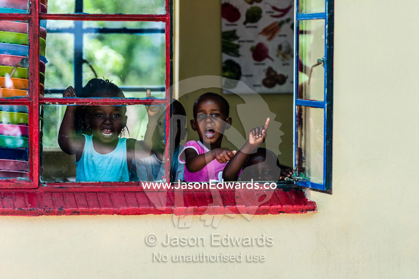 School children yelling goodbye from their classroom window. Kruger National Park, Manyeleti, Shalati Village, Mnisi Community, Limpopo, South Africa.