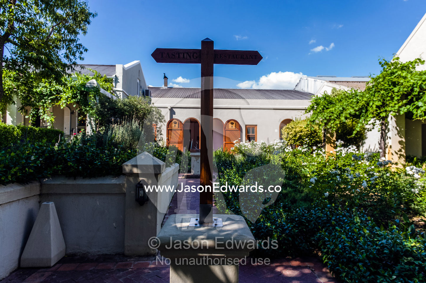 A sign in a winery garden to the tasting room and the restaurant. Fairview Wine Estate, Stellenbosch, Western Cape, South Africa.