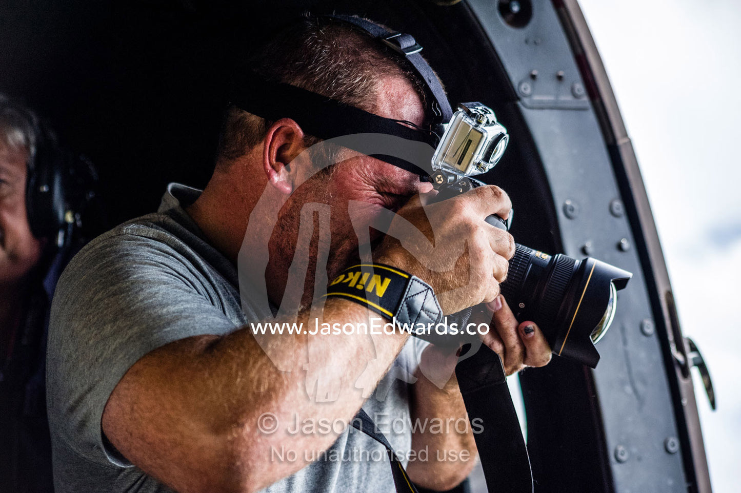 A photographer filming out of the door of a helicopter. The Lowveld Area, Olifants River, Kruger National Park, South Africa.