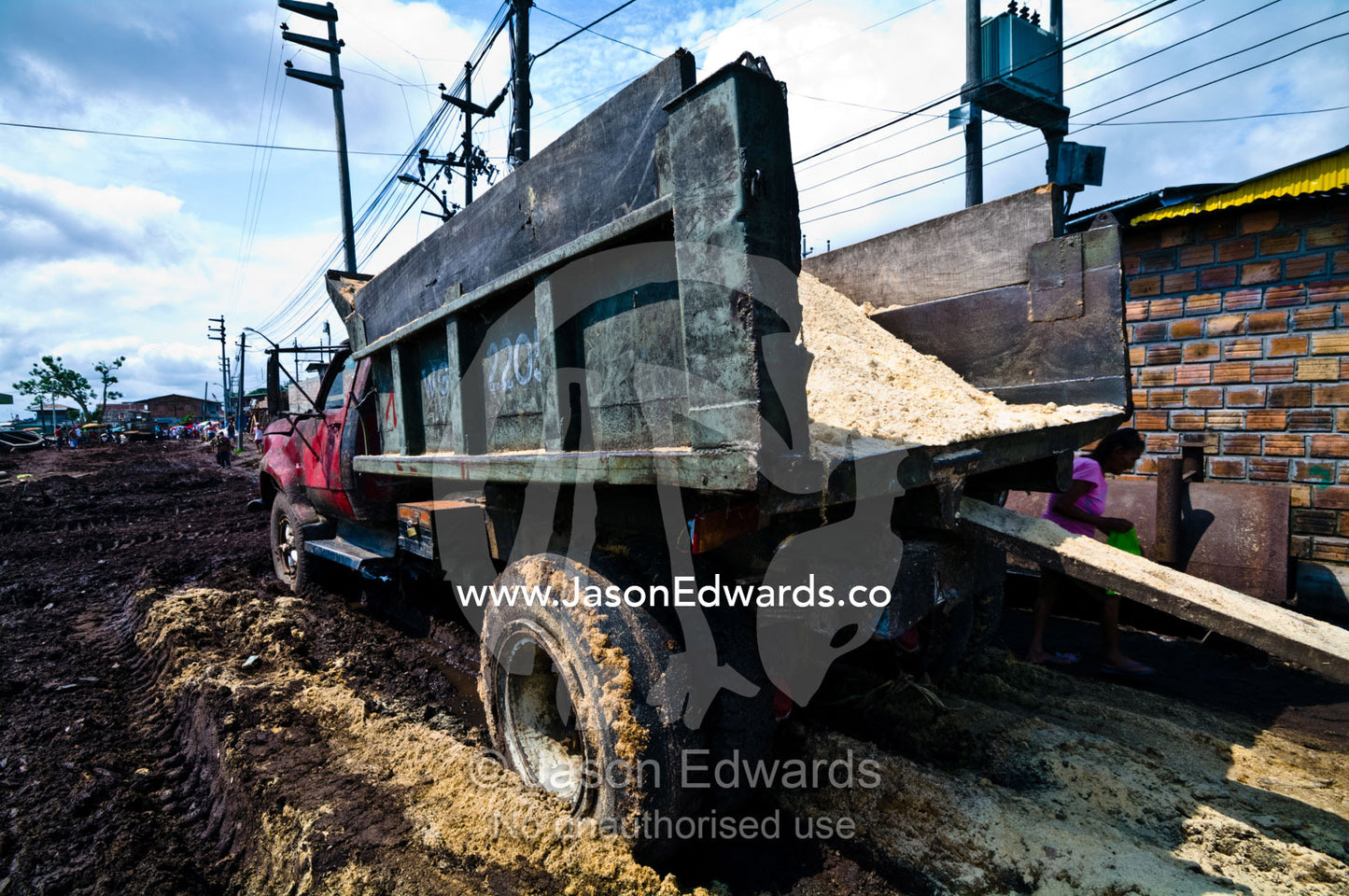 A truck takes sawdust from logging mills to recycle as flooring in village homes and farms. Puerto Masusa, Iquitos, Amazon Basin, Loreto Region, Maynas Province, Peru.