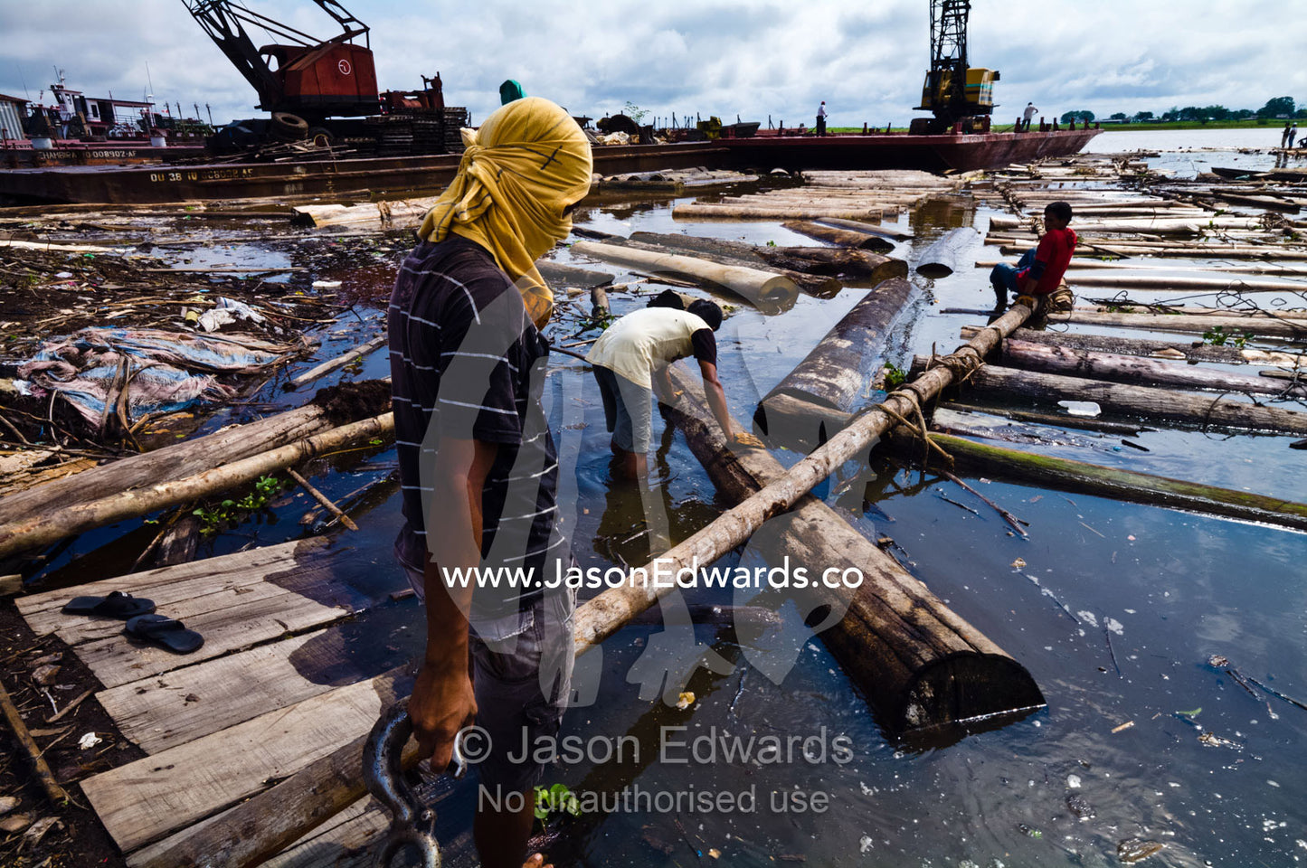Laborers create a makeshift ramp to unload timber from a barge for processing. Puerto Masusa, Iquitos, Amazon River, Rio Amazonas, Amazon Basin, Loreto Region, Maynas Province, Peru.