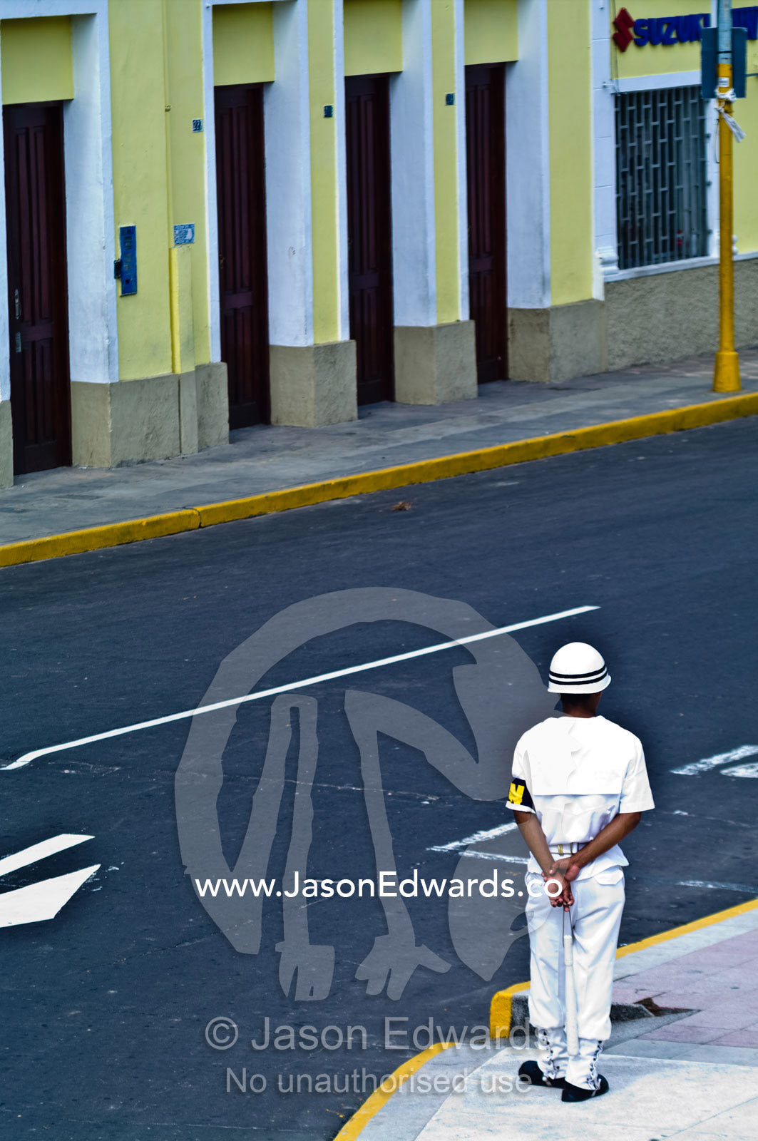 A military police officer patrols a street corner during a military parade honoring fallen comrades. Plaza de Armas, Iquitos, Amazon Basin, Loreto Region, Maynas Province, Peru.