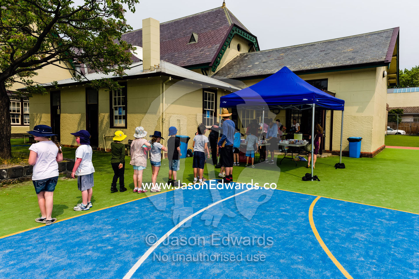 Children line up for a free hotdog at a school fundraising walkathon. Carlton North Primary School, Carlton North, Melbourne, Victoria, Australia.