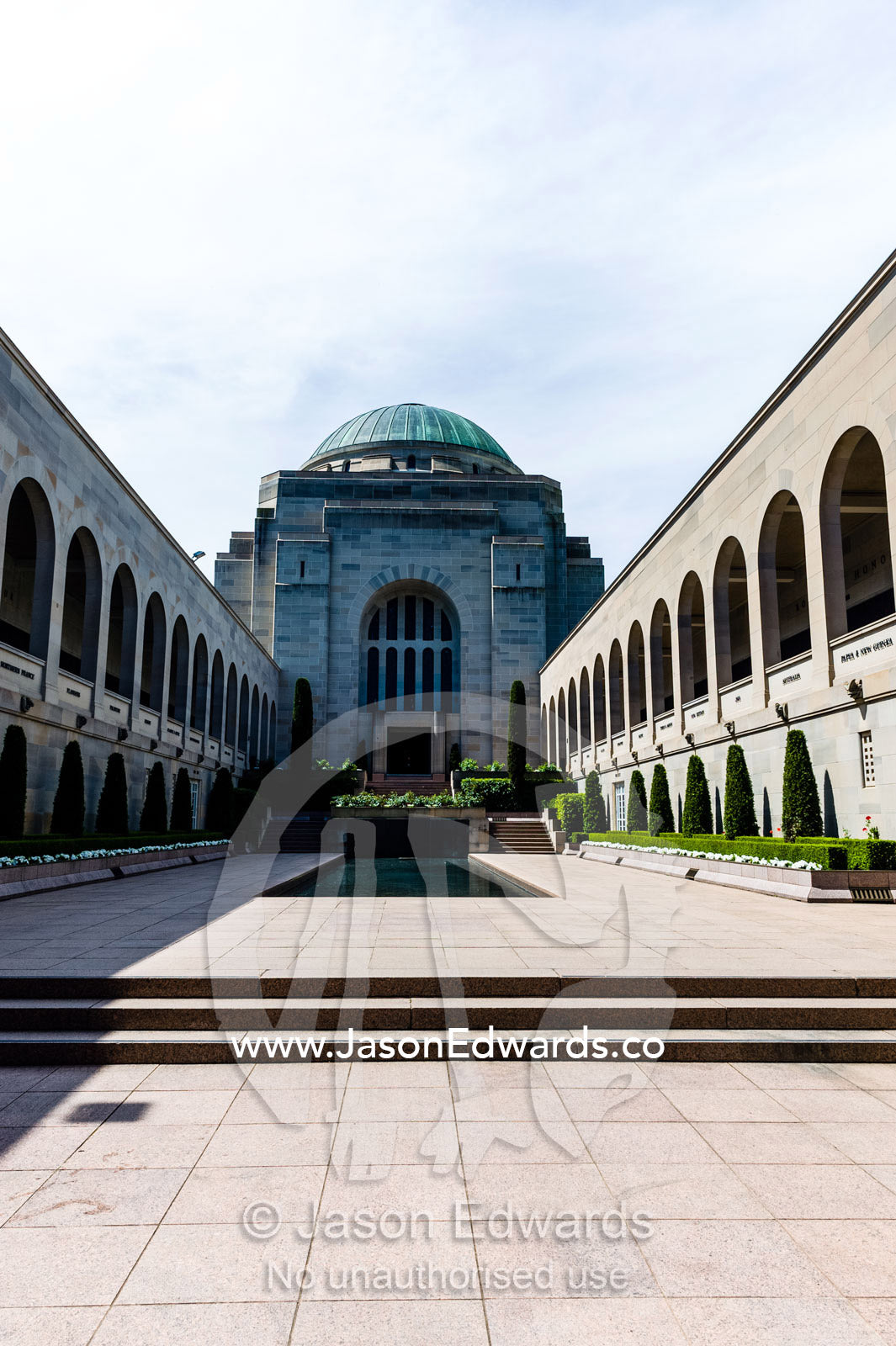 Cloisters containing the Roll of Honour overlook the Memorial Courtyard, Eternal Flame and Memorial Pool leading to the Hall of Memory. Australian War Memorial, Canberra, Australian Capital Territory, Australia.