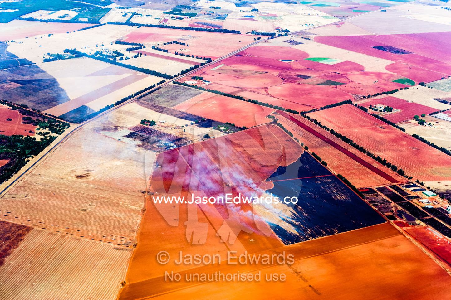 Smoke rises from agricultural crops being burned on a vast plain of arid farmland. Johannesburg, Gauteng Province, South Africa, Africa.