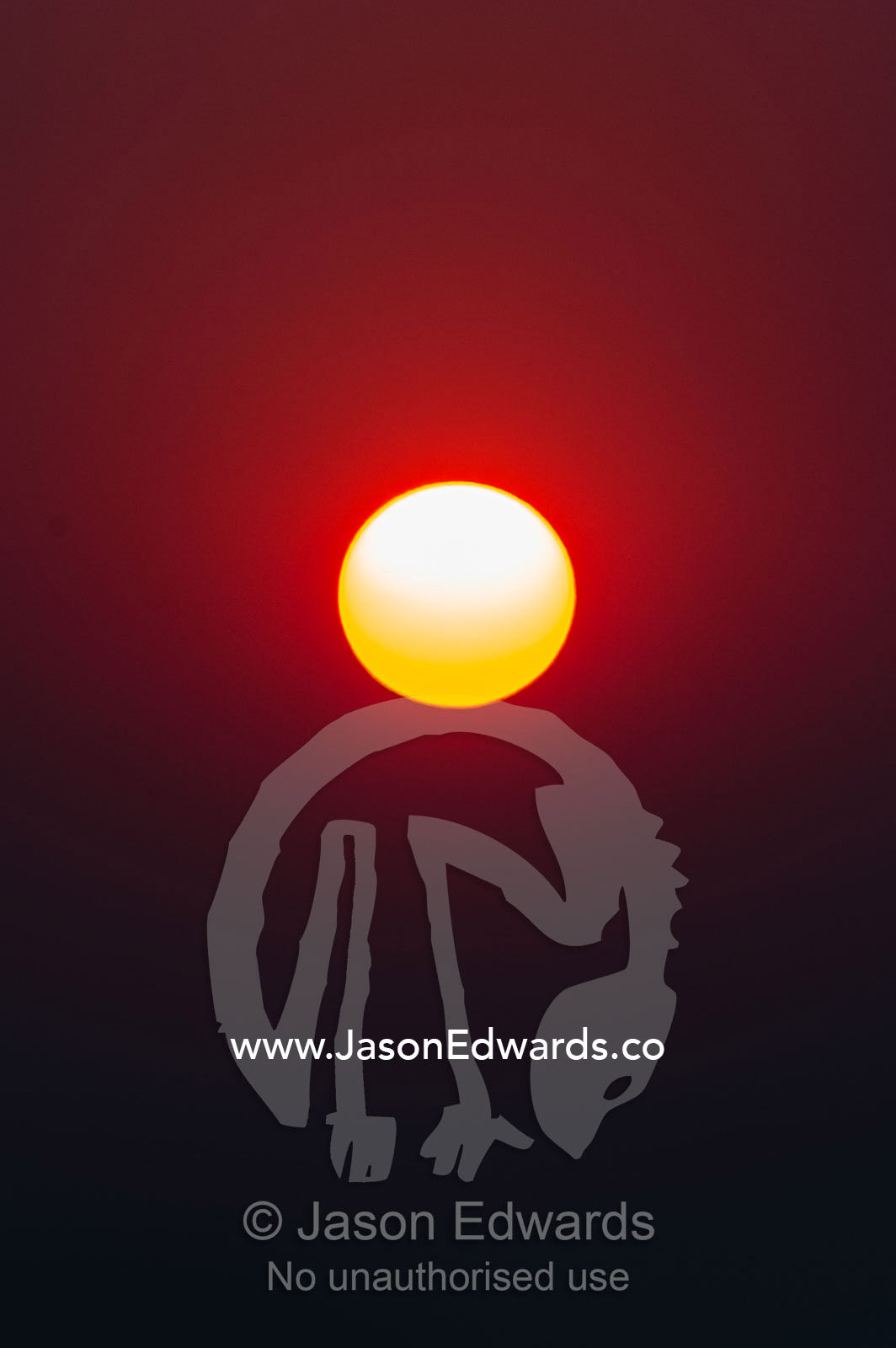 A blazing sunset turns deep red from smoke from land clearing in Zambia. Chobe River, Chobe National Park, Botswana.