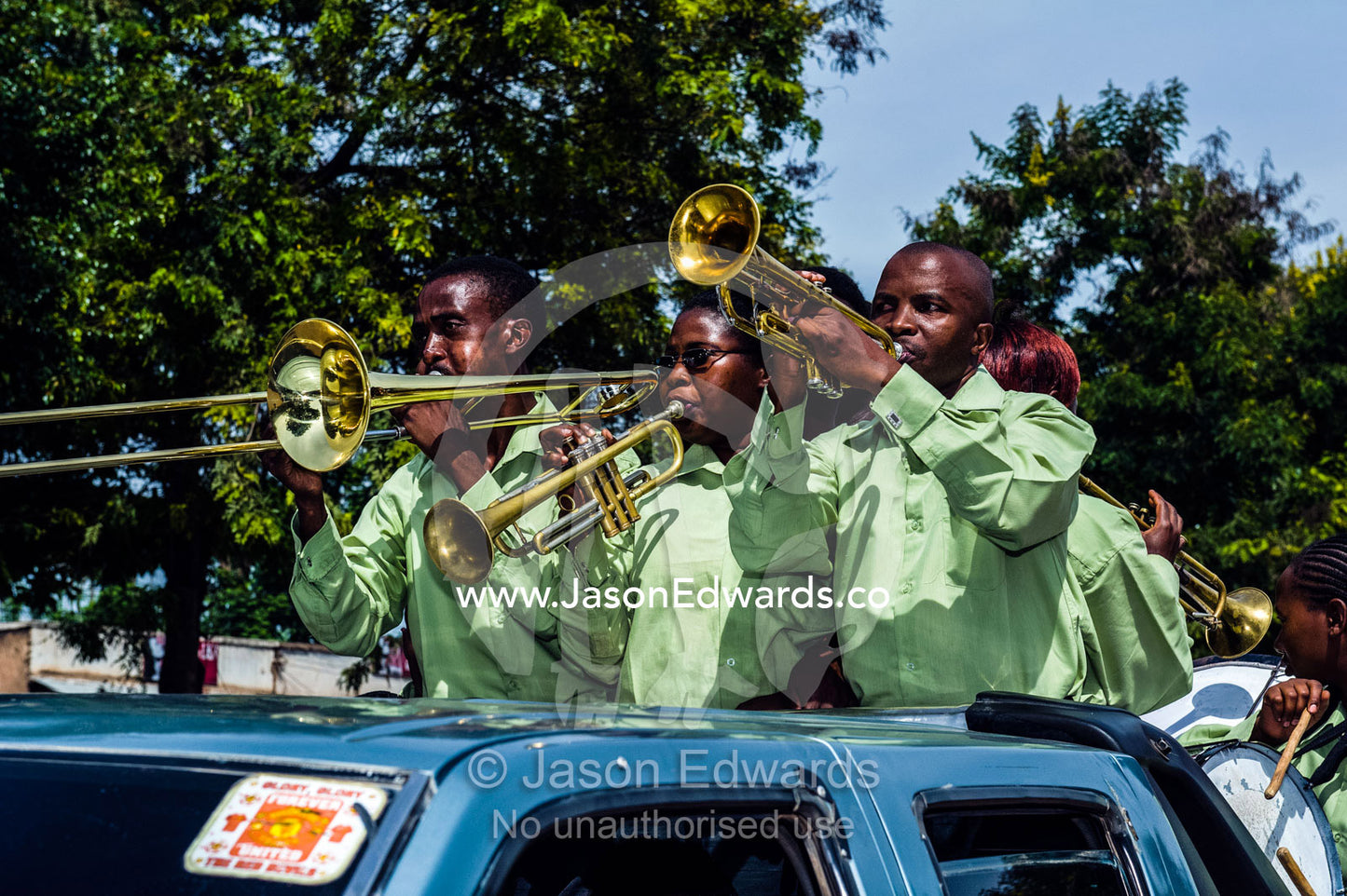 A band plays music for a wedding procession from a utility vehicle in the main street of a village. Mto Wa Mbu, Lake Manyara National Park, Monduli District, Arusha Region, Tanzania, Africa.