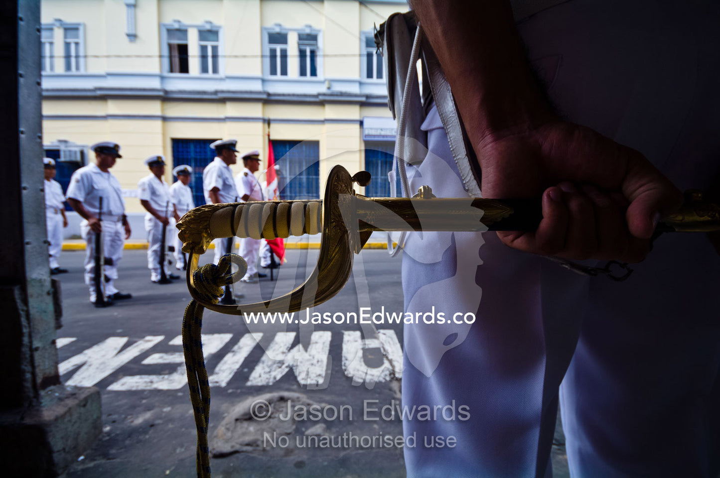 A Peruvian naval officer in dress uniform stands holding a ceremonial sword. Plaza de Armas, Iquitos, Amazon Basin, Loreto Region, Maynas Province, Peru.