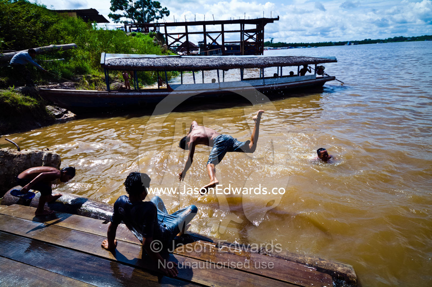 In the heat of the day, young boys enjoy the thrill of a midday swim at the local river jetty. Iquitos, Rio Amazonas, Rio Nanay, Loreto Region, Maynas Province, Amazon Basin, Peru.