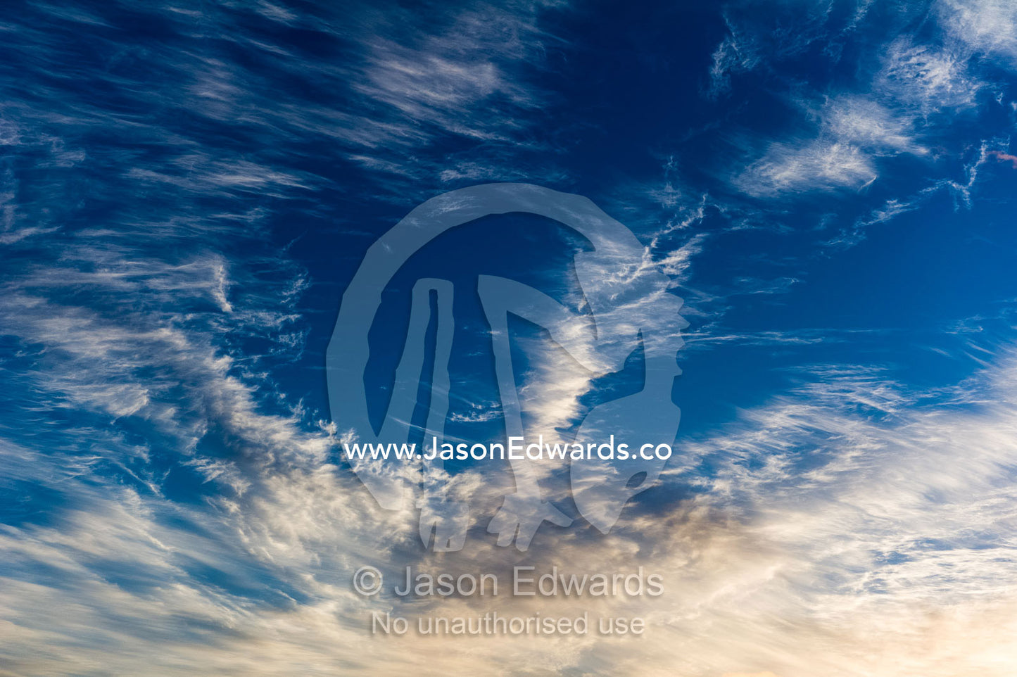 Sunset touches the wispy leading edge of a cirrus clouds. Auckland, New Zealand.
