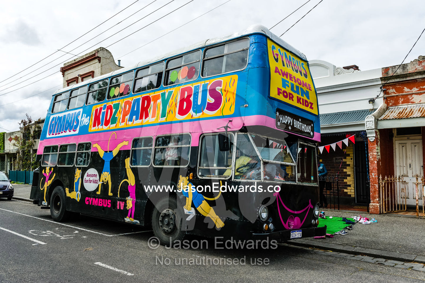 Children playing on a double-decker bus converted into a birthday party venue for gymnastic activities. Carlton North, Melbourne, Victoria, Australia.