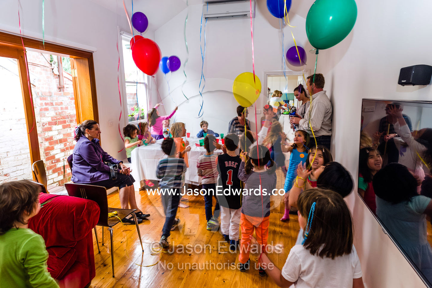 Children playing with balloons at a birthday party. Carlton North, Melbourne, Victoria, Australia.