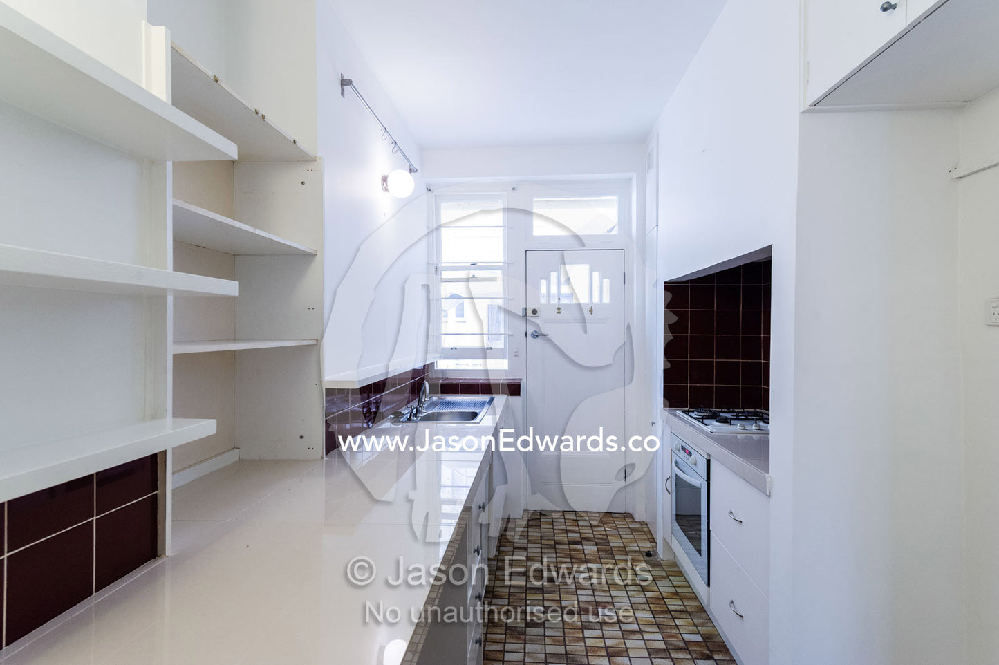 A kitchen in an empty rental apartment freshly painted in white. St Kilda Road, Melbourne, Victoria, Australia.