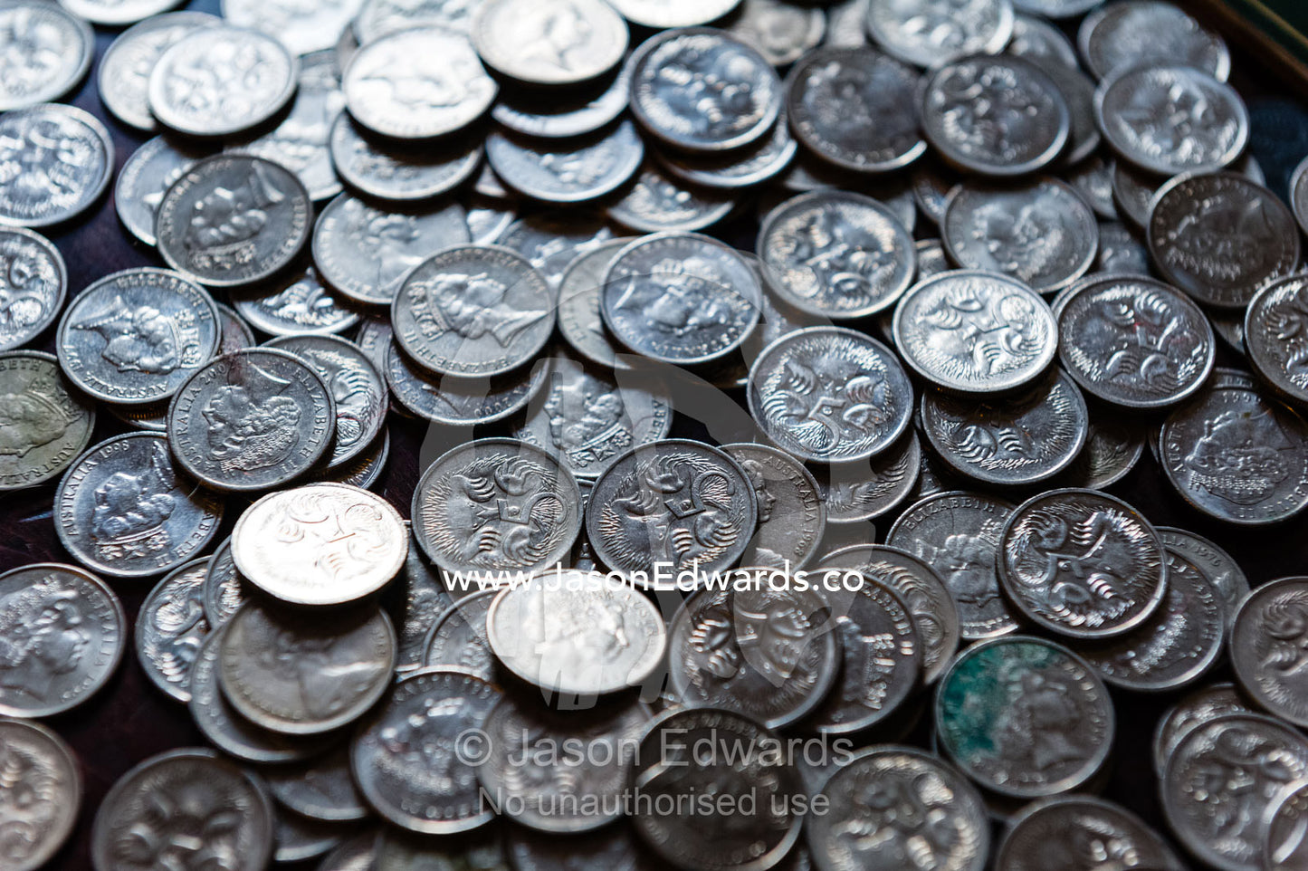 Coins from a child's money-box being sorted into their currency denominations for counting at the bank. Carlton North, Melbourne, Victoria, Australia.