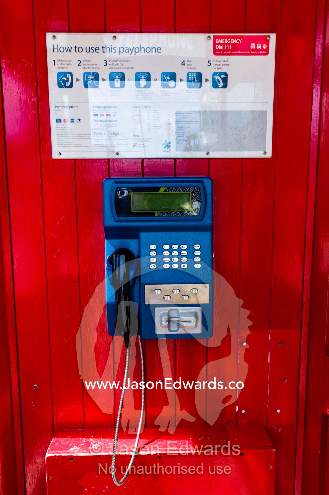 A public telephone in an antique bright red English telephone box. Christchurch, South Island, New Zealand.