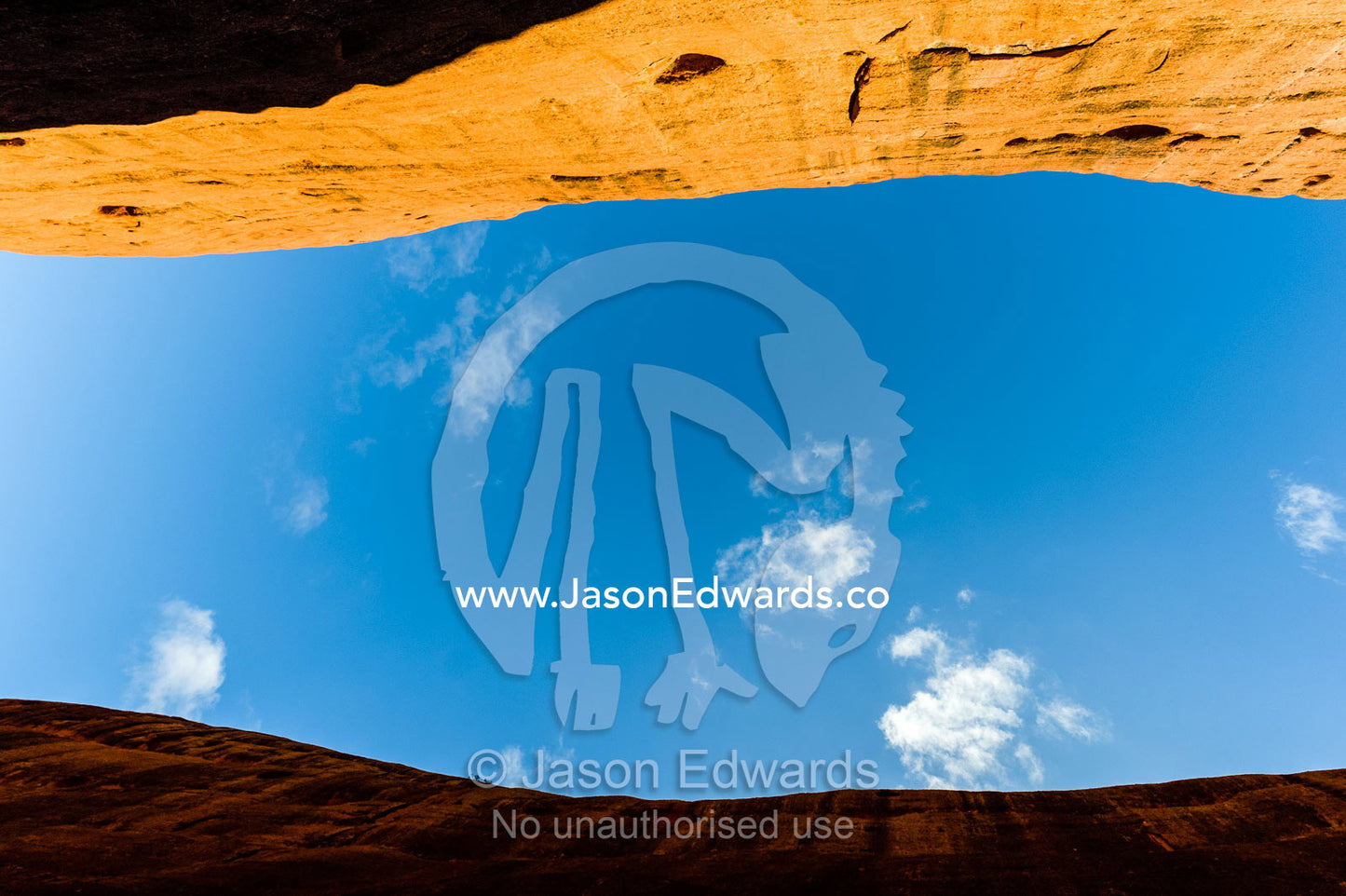Clear blue sky is sandwiched between ochre sandstone walls in the desert. Uluru Kata Tjuta National Park, Northern Territory, Australia.