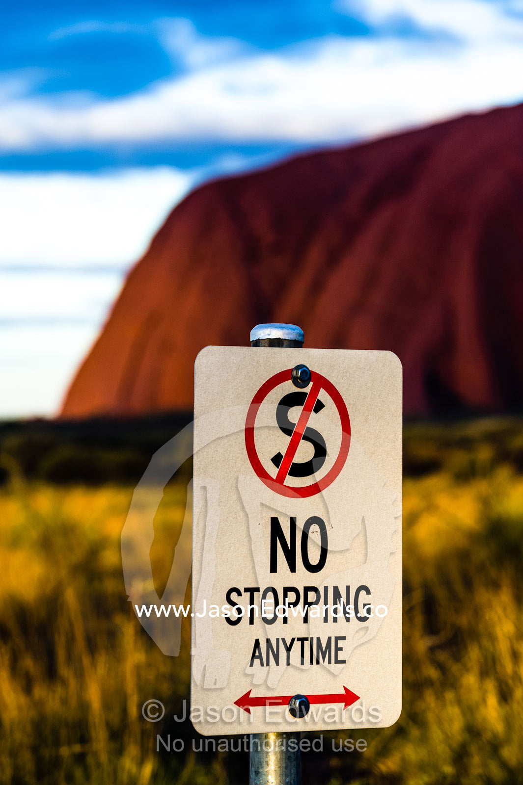 A sign prevents tourists from stopping along the road to view Uluru. Uluru Kata Tjuta National Park, Northern Territory, Australia.