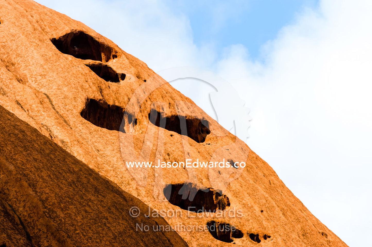 Folds, holes and fissures caused by water and wind erosion in the sandstone surface of Uluru. Uluru Kata Tjuta National Park, Northern Territory, Australia.