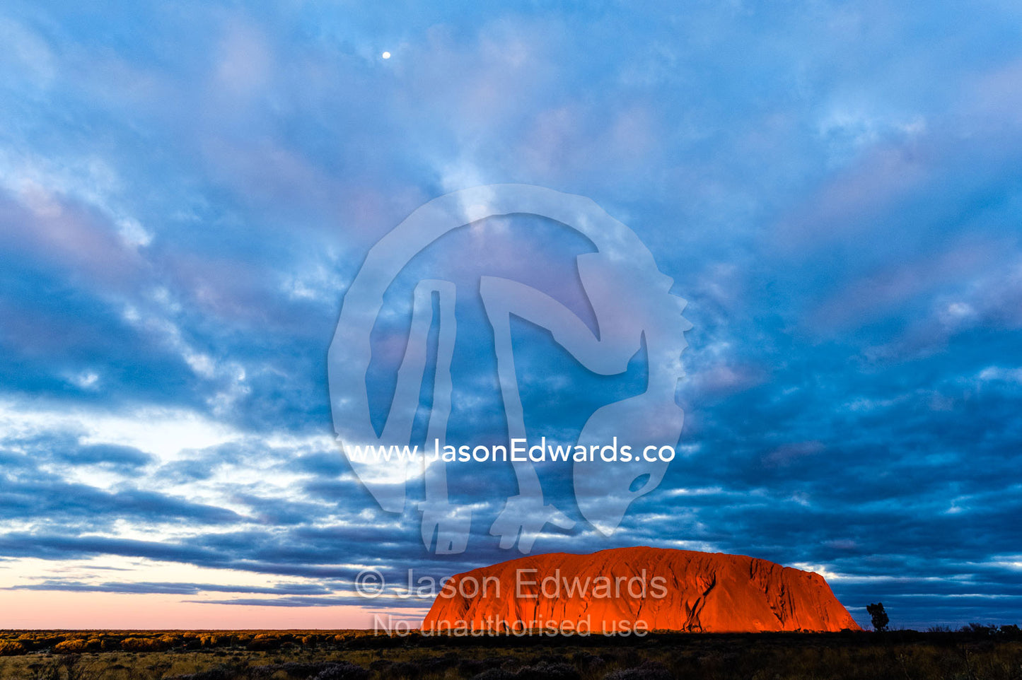 A cloud bank from an approaching storm turns magenta as it shrouds Uluru and the desert plain. Uluru Kata Tjuta National Park, Northern Territory, Australia.