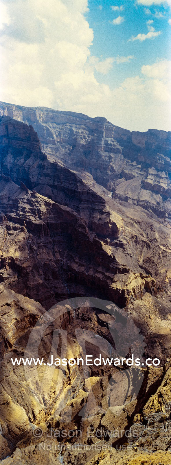 Sheer cliff walls and terraces carved by erosion in a massive desert canyon. Wadi Ghul, Jebel Shams, Al Hajar Mountains, Sultanate of Oman.