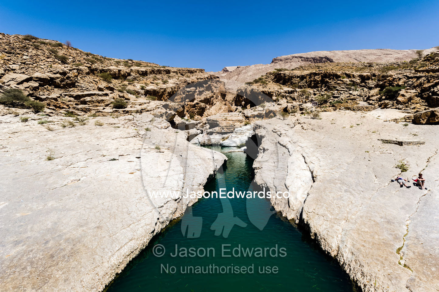 The cool, clear turquoise waters of a wadi in a desert canyon. Wadi Bani Khalid, Sharqiyah Region, Sultanate of Oman.