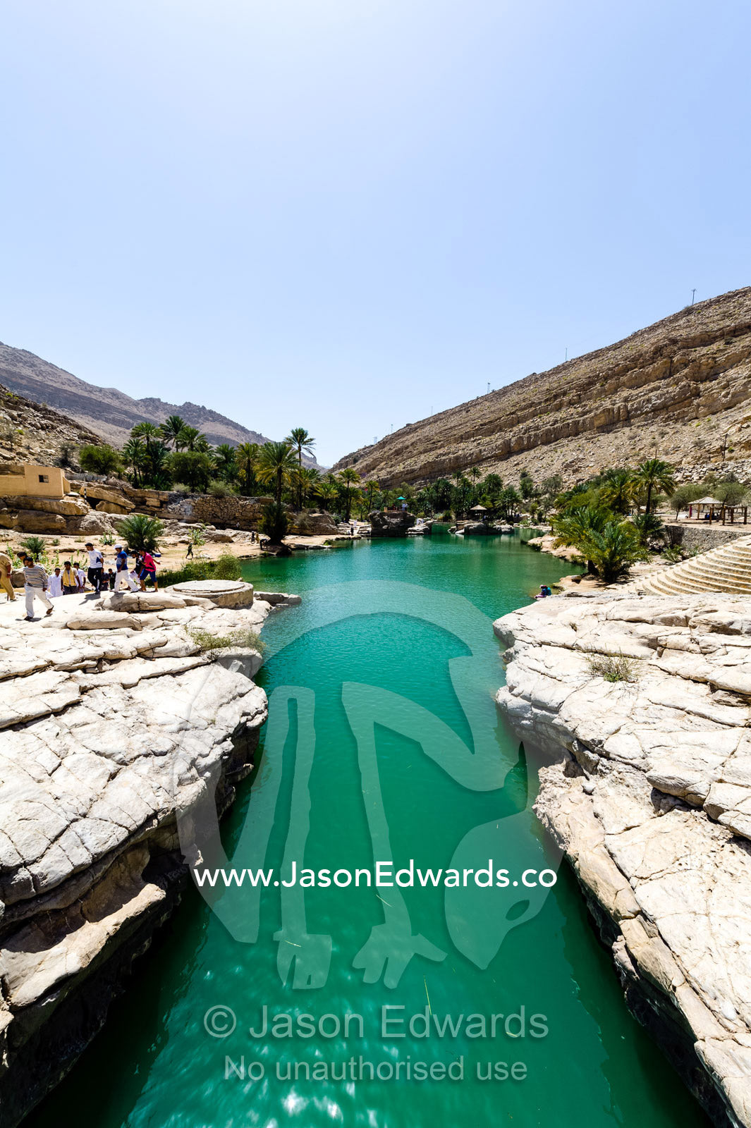 The cool, clear turquoise waters of a wadi in a desert canyon. Wadi Bani Khalid, Sharqiyah Region, Sultanate of Oman.