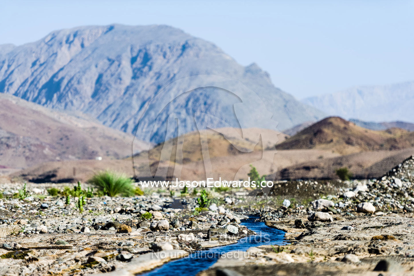 Water runs through a falaj in the desert and is used to irrigate crops and livestock in remote villages. Wadi Fanja, Dima Wal Taeen, North Al Sharqiyah Governorate, Sultanate of Oman.