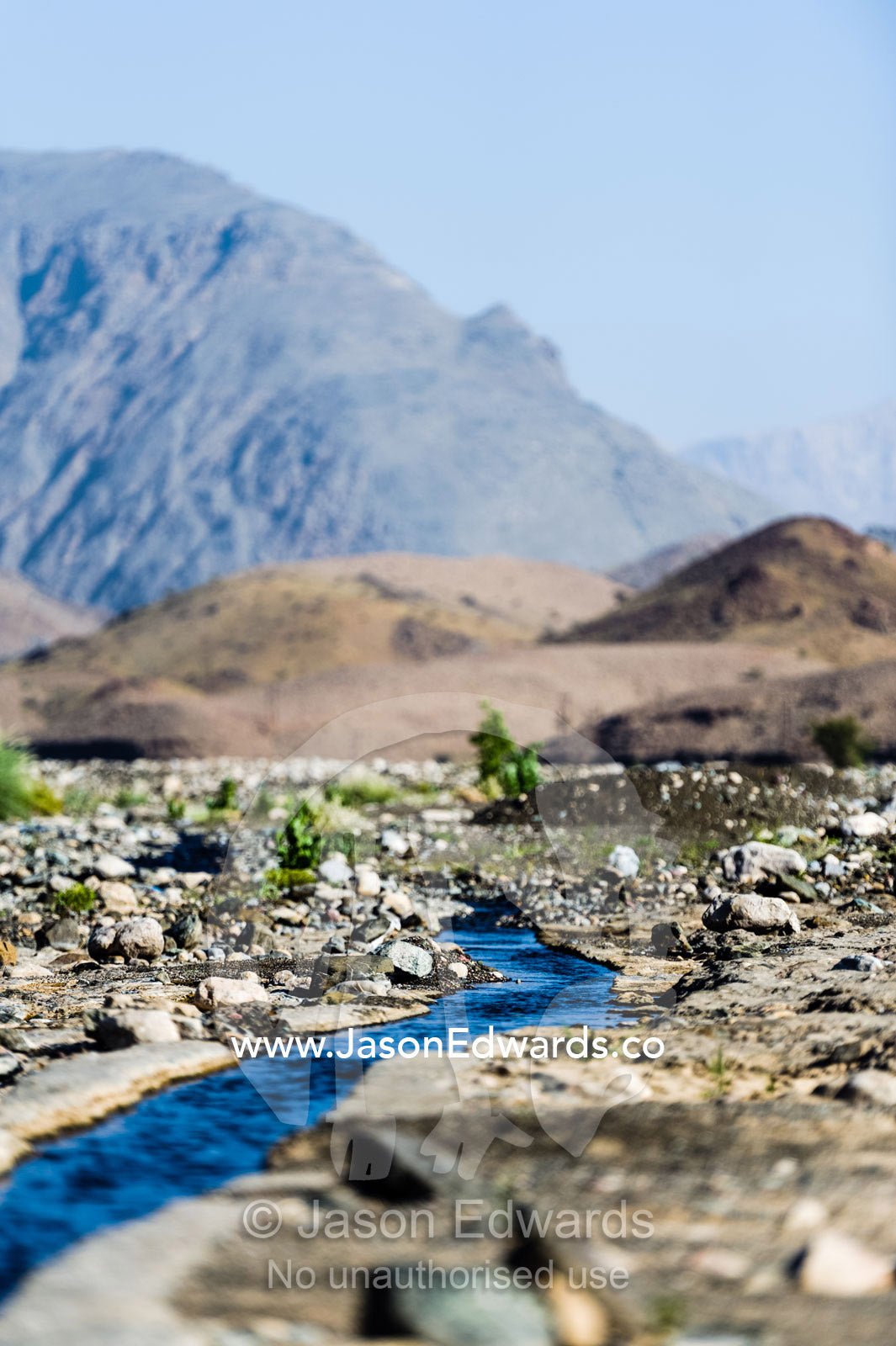 Water runs through a falaj in the desert and is used to irrigate crops and livestock in remote villages. Wadi Fanja, Dima Wal Taeen, North Al Sharqiyah Governorate, Sultanate of Oman.