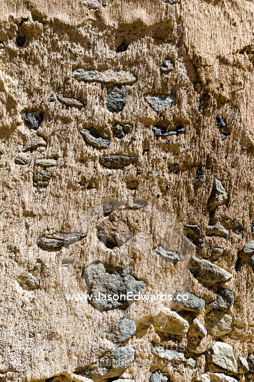 The detail of a sand and stone mud brick wall in an ancient desert village. Ibra, Ash Sharqiyah Region, Sultanate of Oman.