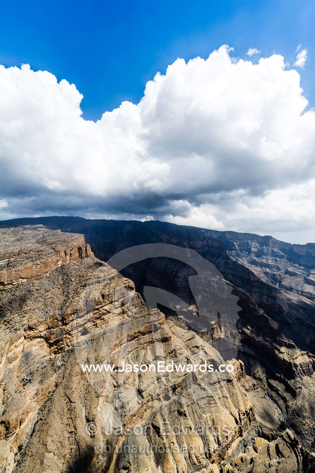 Sheer cliff walls and terraces carved by erosion in a massive desert canyon. Wadi Ghul, Jebel Shams, Al Hajar Mountains, Sultanate of Oman.