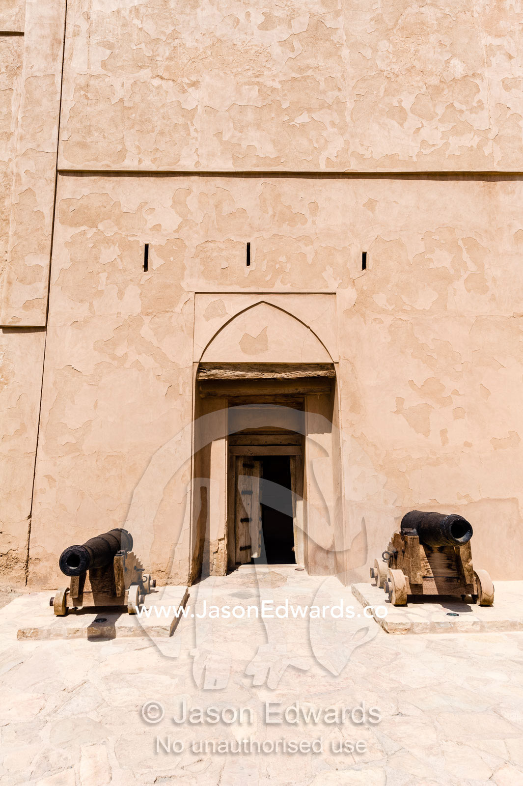 Cannons guard a door in the sheer walls of Jabrin Fort. Jabrin Fort, Ad Dakhiliyah Governorate, Sultanate of Oman.