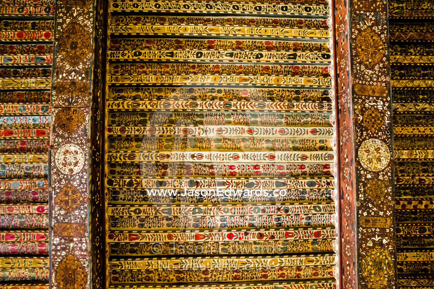 An ancient timber ceiling decorated in ornate paintings and filligree in the Majlis of an ancient fort. Jabrin Fort, Ad Dakhiliyah Governorate, Sultanate of Oman.