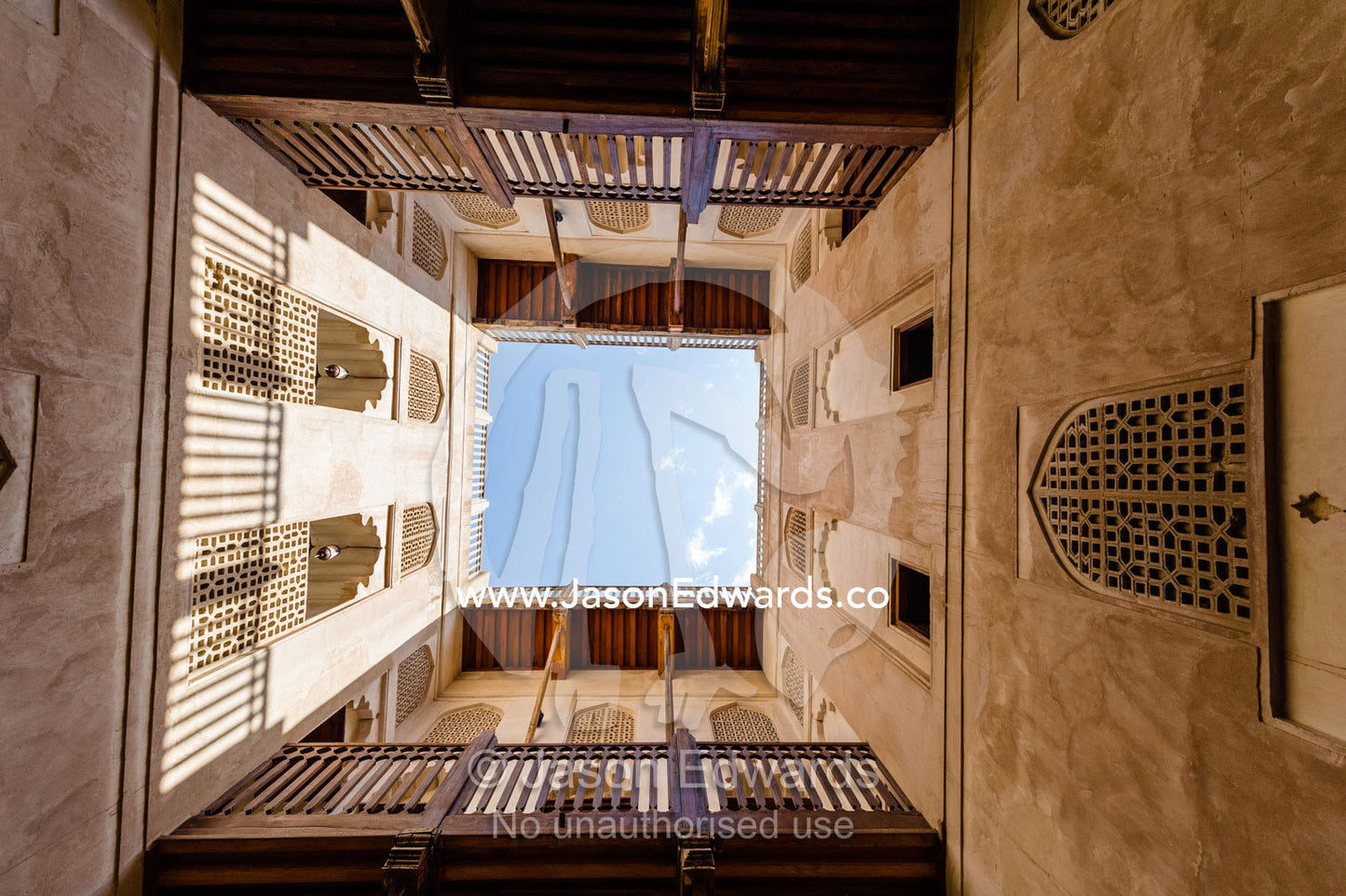 Timber balconies overlook latticed windows and a shaded courtyard in an ancient fort. Jabrin Fort, Ad Dakhiliyah Governorate, Sultanate of Oman.