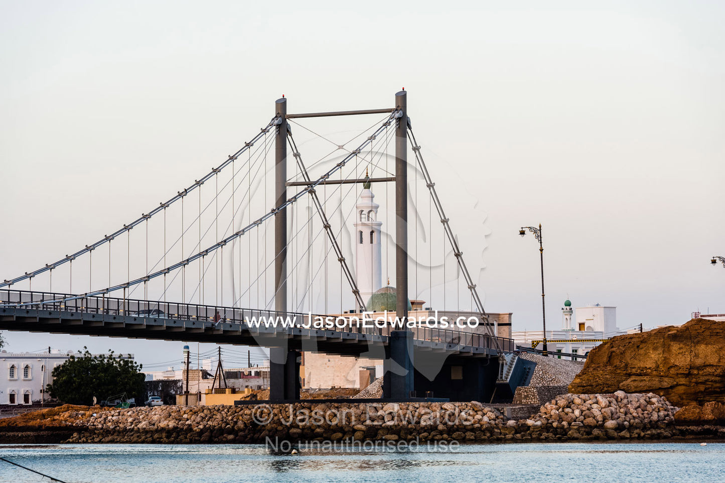 A suspension bridge straddles an ocean inlet in the Gulf of Oman. Sur, Ash Sharqiyah Region, Gulf of Oman, Sultanate of Oman.