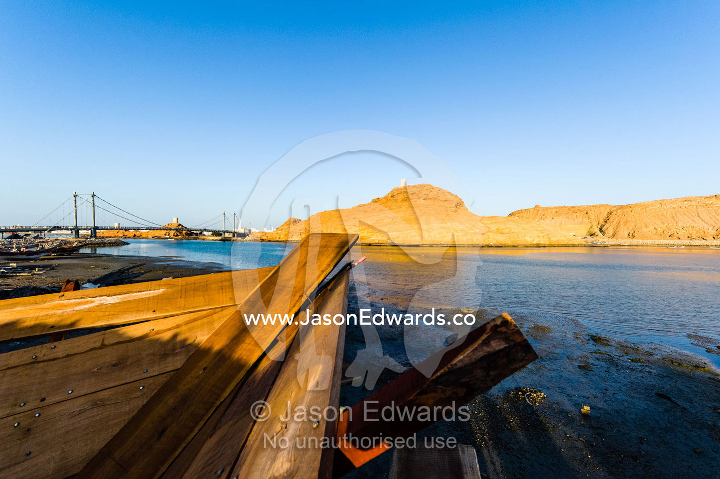 Raw timber planks on the bow of a dhow during construction overlooking the Gulf of Oman. Sur, Ash Sharqiyah Region, Gulf of Oman, Sultanate of Oman.