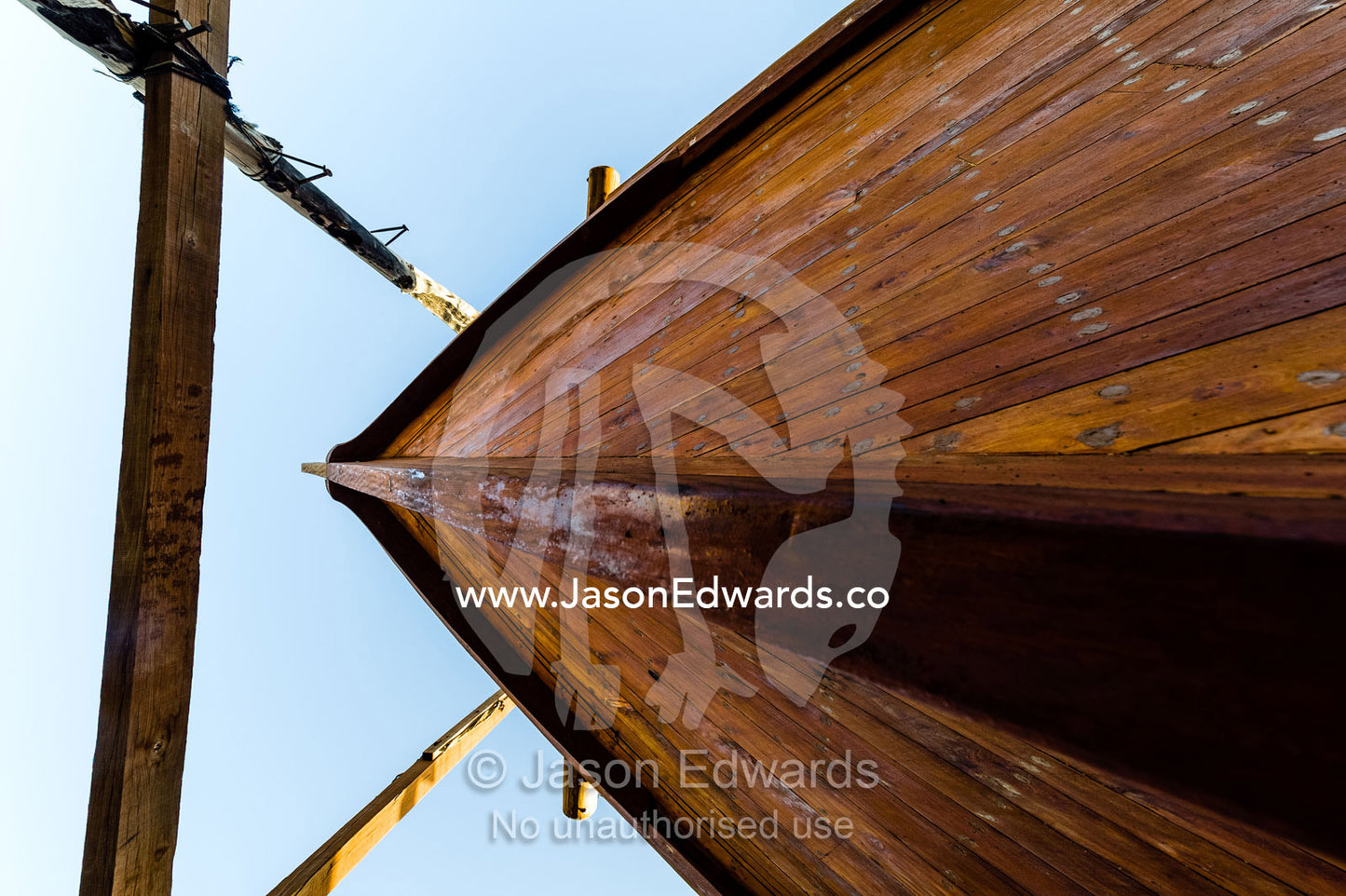 Nail holes filled with putty and freshly oiled timber hull planks on a dhow under construction. Sur, Ash Sharqiyah Region, Gulf of Oman, Sultanate of Oman.