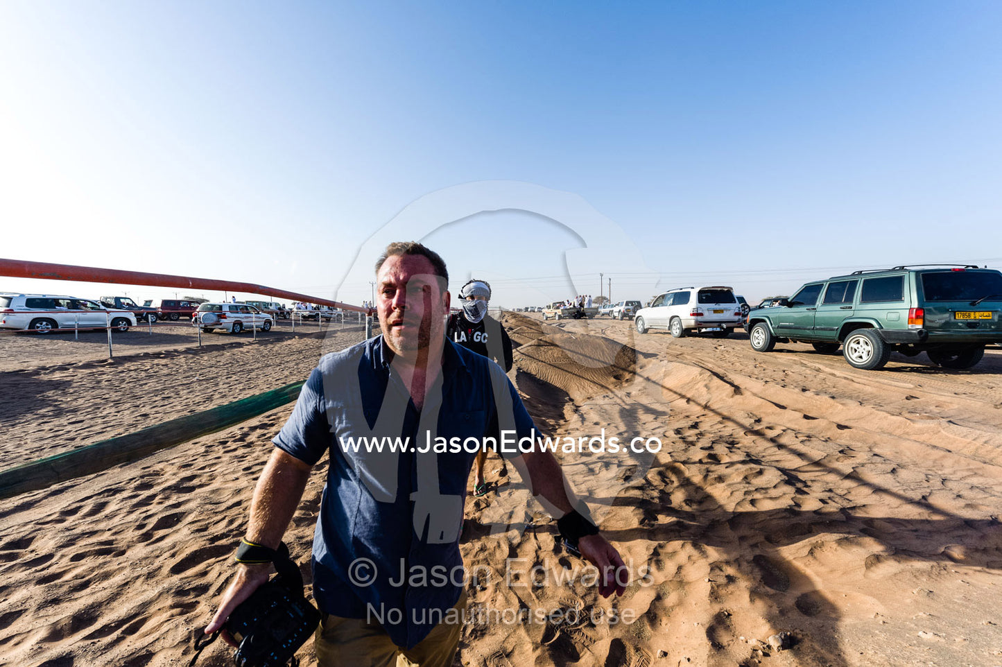 National Geographic photographer Jason Edwards photographing at a camel race in the desert. Bidiya, Sharqiya Region, Sultanate of Oman.
