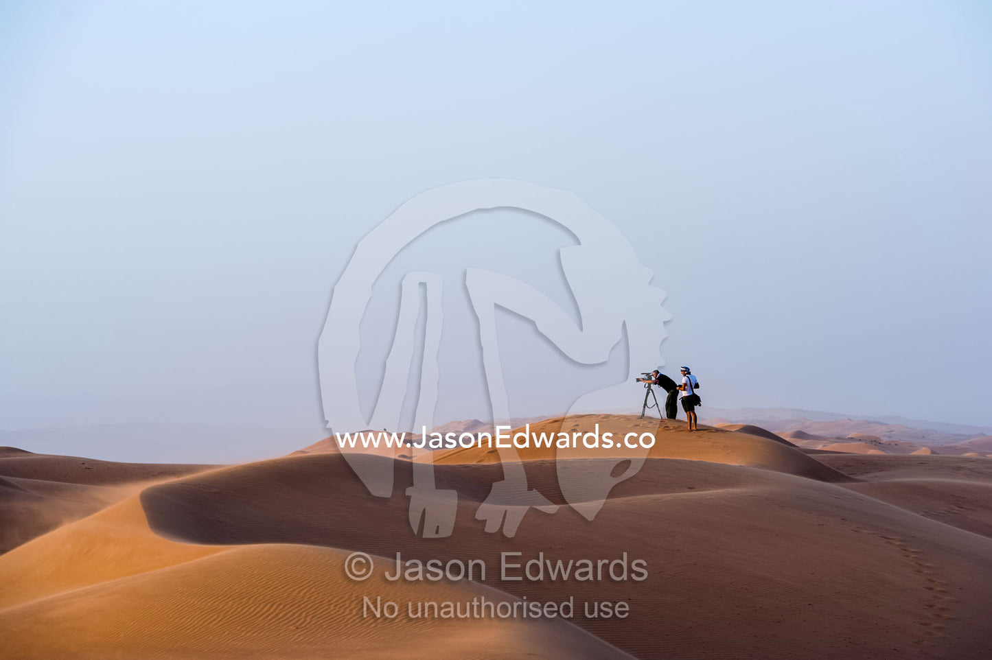 A television crew films the sunset from a sand dune in the desert. Wahiba Sands, Ramlat al-Wahiba, Sharqiya Sands, Sultanate of Oman.