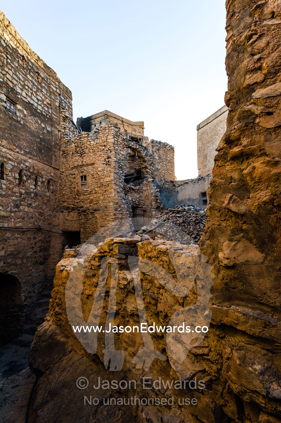 The ruins of an ancient mud brick village wall and alley. Misfat Al Abryeen, Al Hajar Mountains, Al Hamra, Ad Dakhiliyah Region, Sultanate of Oman.