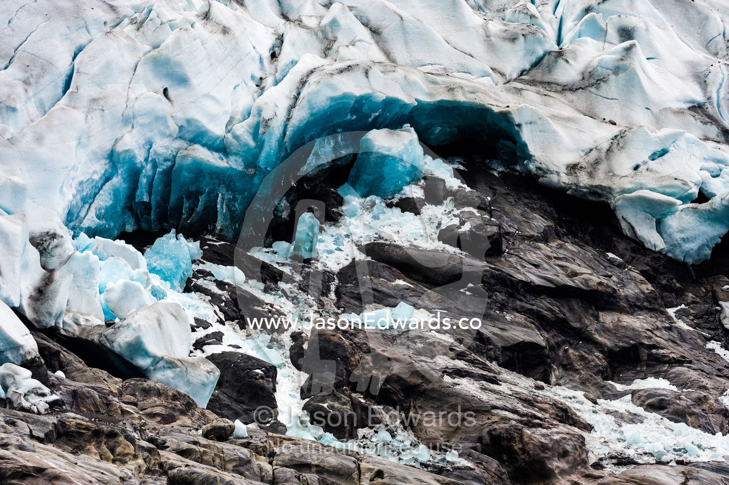 A jagged glacier tongue recedes up a rugged and inhospitable mountain in a fiord. Fjord of Eternity, Maniitsoq, Sukkertoppen, Qeqqata Municipality, Greenland.