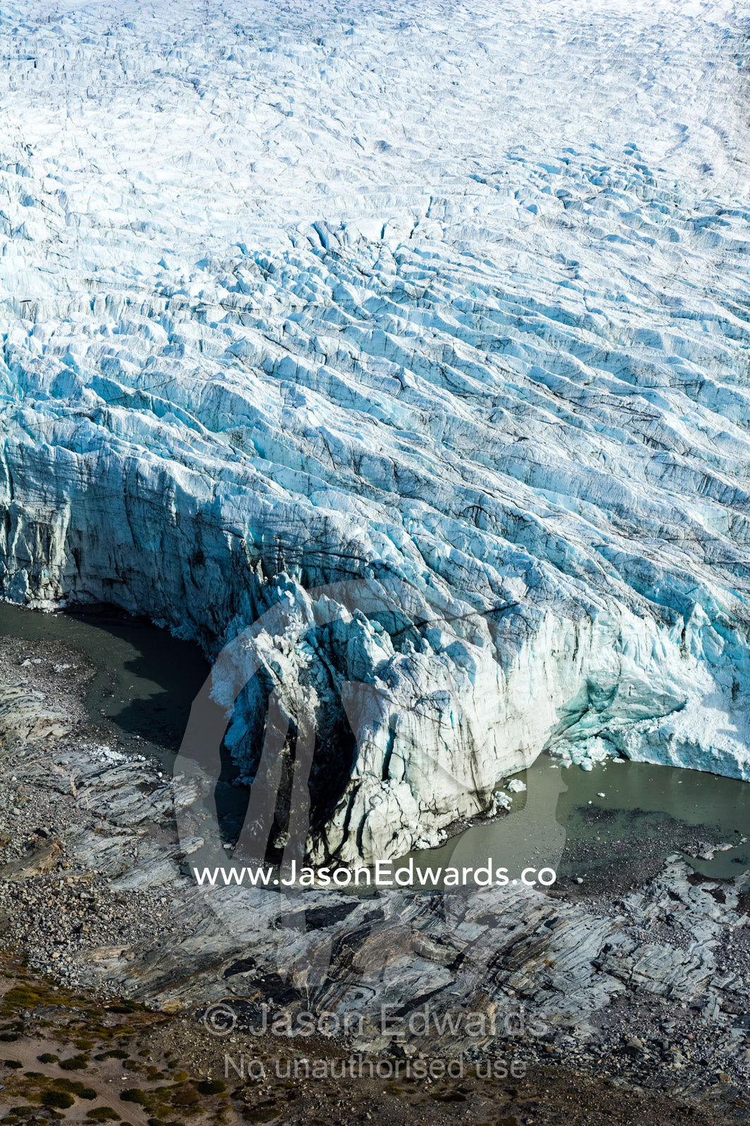 Pressure ridges and crevasse scar the surface of a glacier on the Greenland Ice Sheet. Russell Glacier, Greenland Ice Sheet, Qeqqata Municipality, Kangerlussuaq, Greenland.
