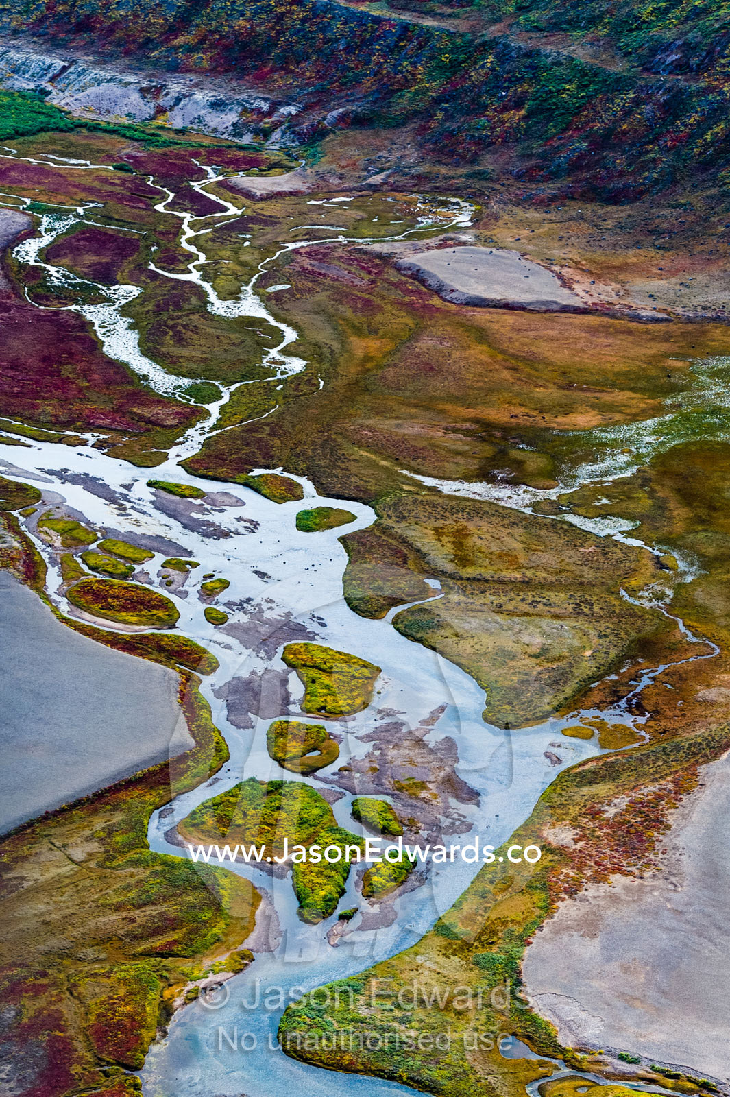A winding river snakes it's way across a highland tundra valley floor. Tarajornitsut Highlands, Qeqqata Municipality, Kangerlussuaq, Greenland.