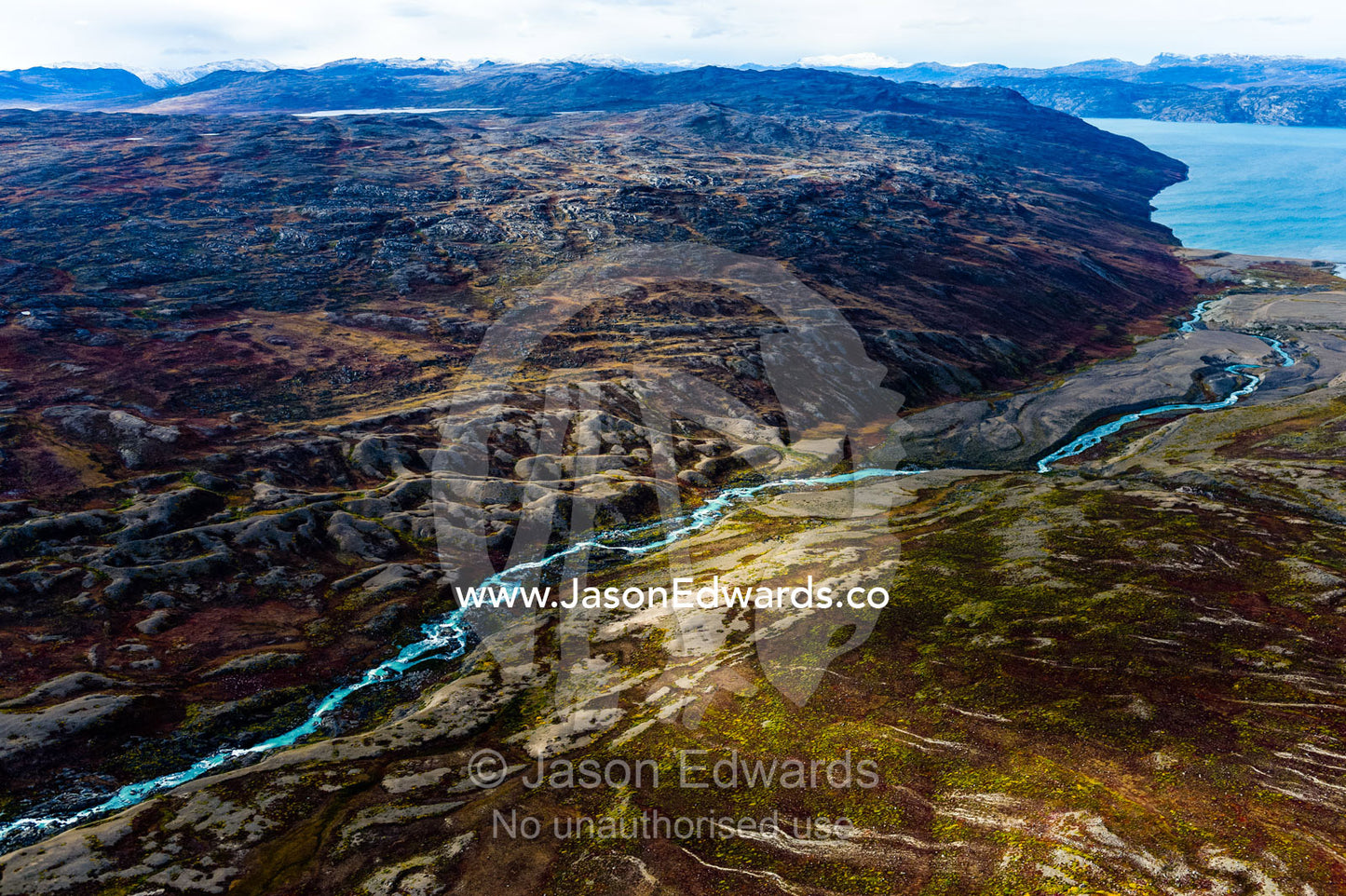 A winding river snakes it's way through a highland tundra valley to a fjord. Tarajornitsut Highlands, Qeqqata Municipality, Kangerlussuaq, Greenland.