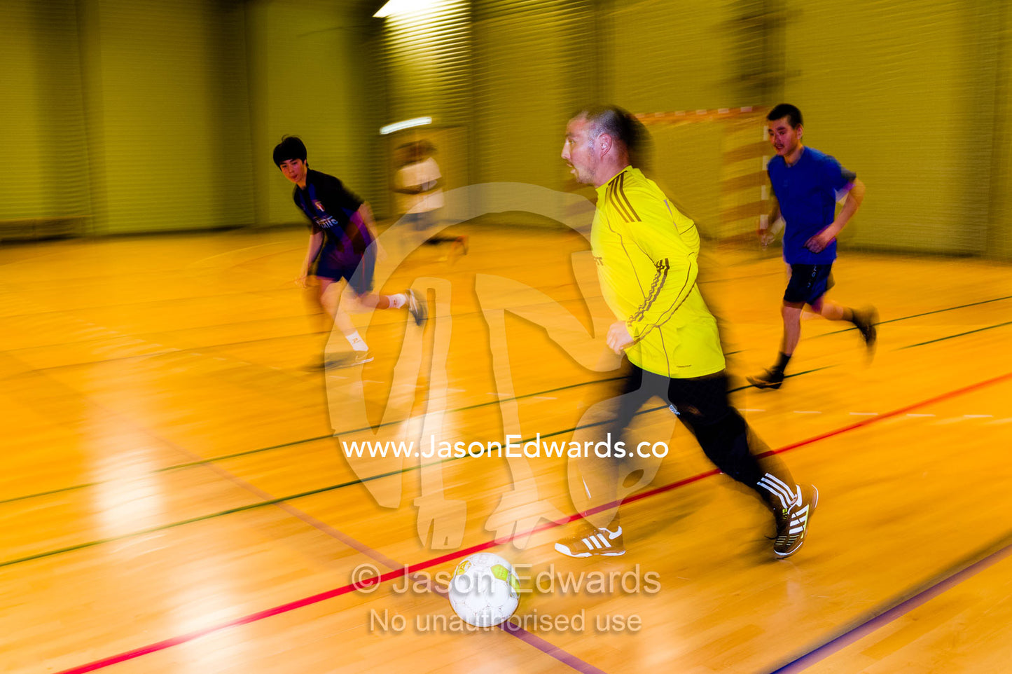 Men playing a fast game of footsal in a gymnasium. Kangaamiut, Gammel Sukkertoppen, Qeqqata Municipality, Greenland.