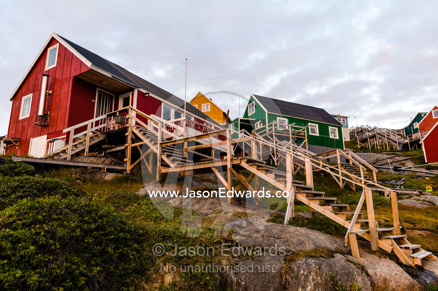 Stairs lead to cottages perched on rocky outcrops in an arctic village. Kangaamiut, Gammel Sukkertoppen, Qeqqata Municipality, Greenland.