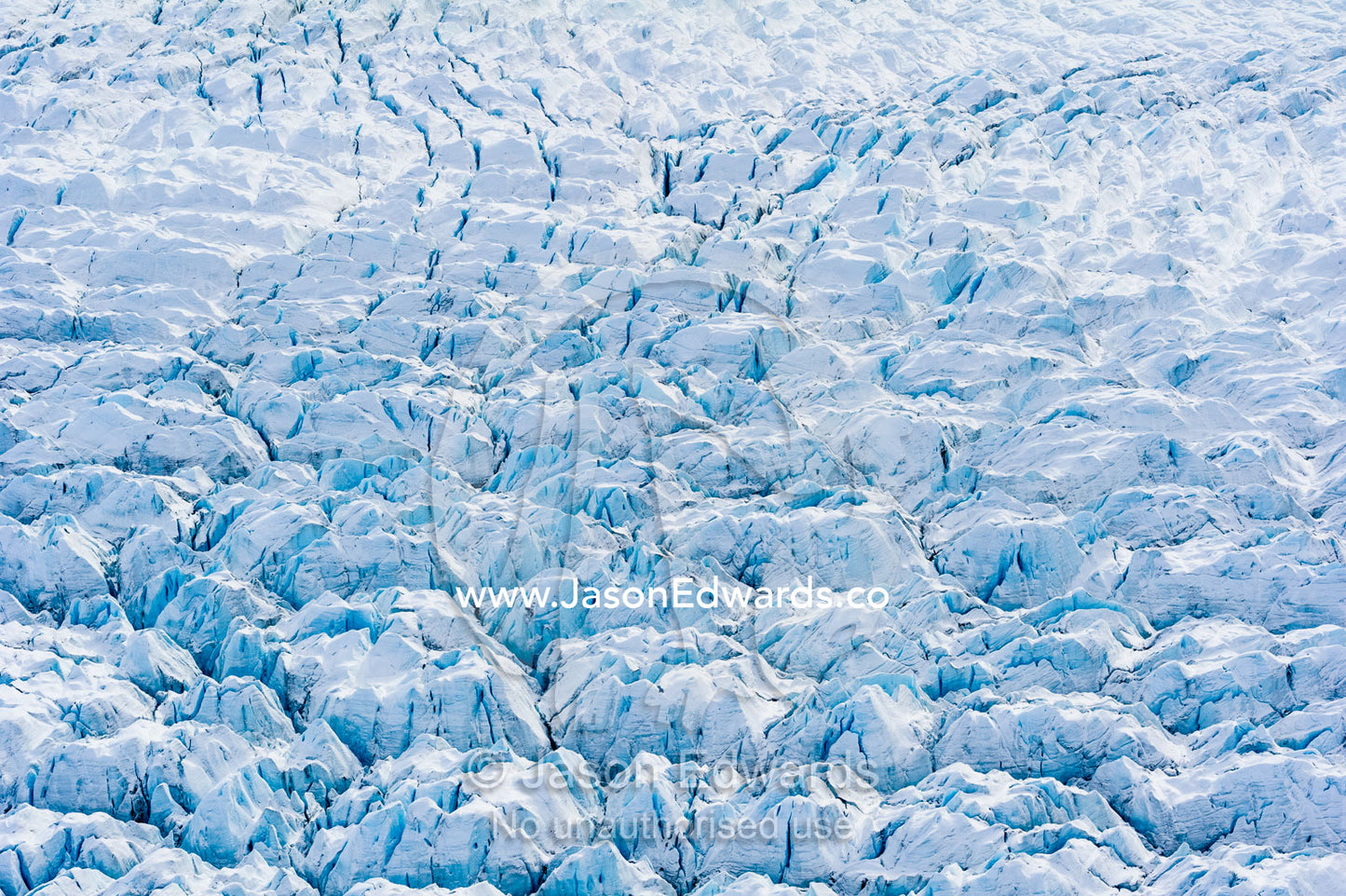Pressure ridges and crevasse scar the surface of a glacier on the Greenland Ice Sheet. Russell Glacier, Greenland Ice Sheet, Qeqqata Municipality, Kangerlussuaq, Greenland.