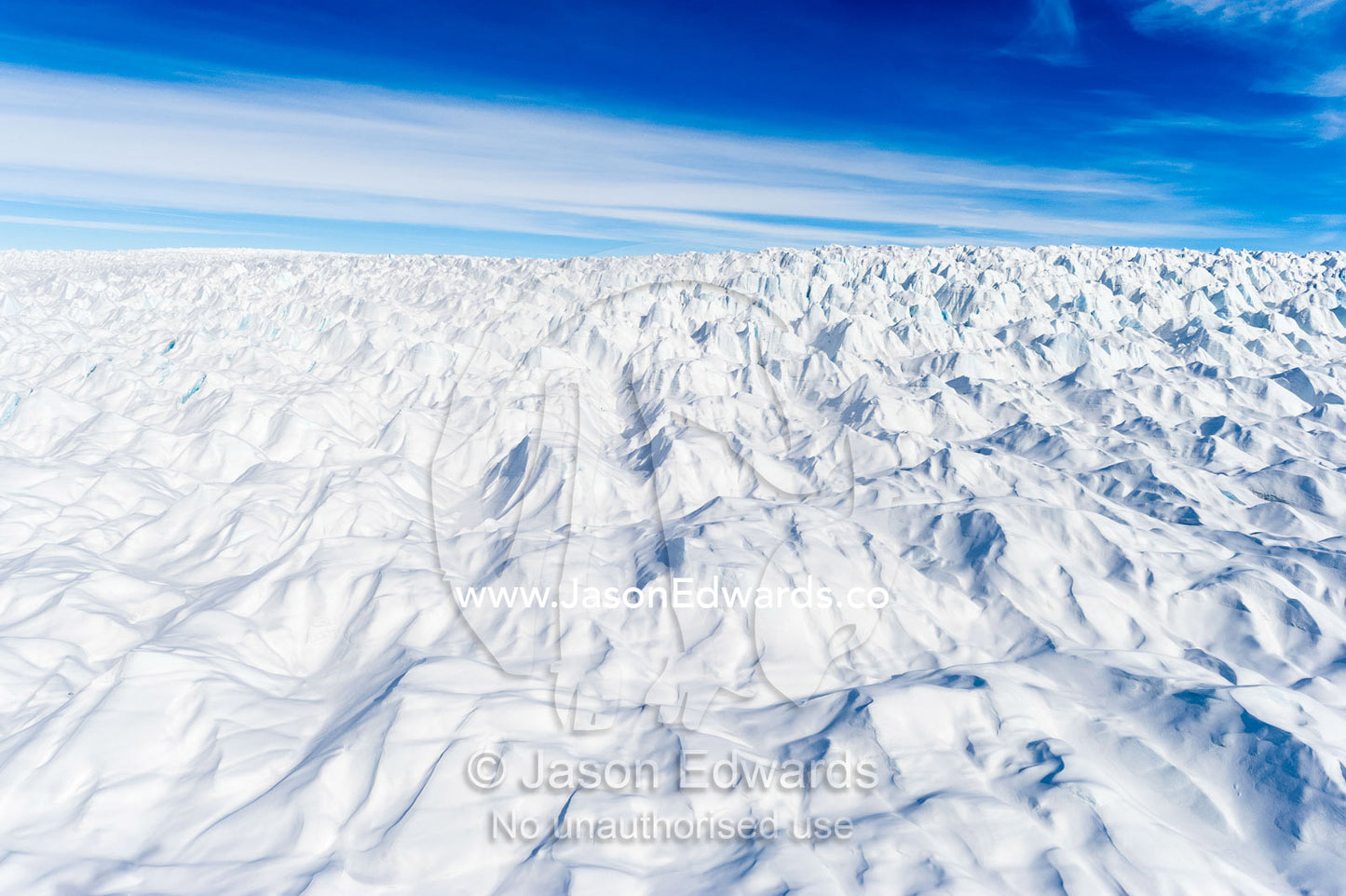 Layers of snow mask deep crevasse on the surface of the vast Greenland Ice Sheet plain. Greenland Ice Sheet, Qeqqata Municipality, Kangerlussuaq, Greenland.