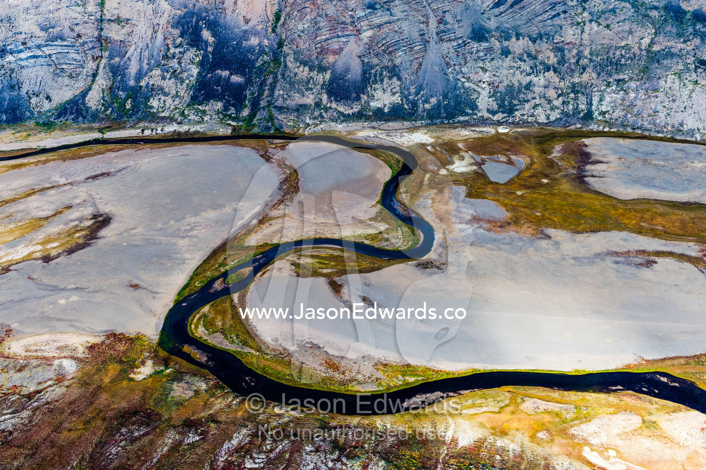 A winding river snakes its way across a highland tundra valley floor. Tarajornitsut Highlands, Qeqqata Municipality, Kangerlussuaq, Greenland.