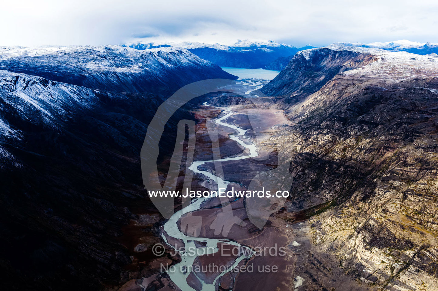 A winding river snakes its way through a highland tundra valley to a fiord. Tarajornitsut Highlands, Qeqqata Municipality, Kangerlussuaq, Greenland.